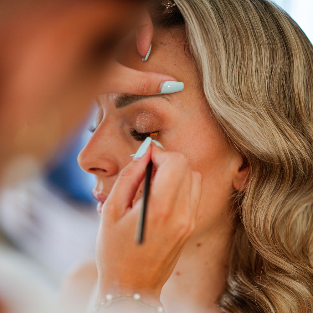 Daphné trace un trait d'eye-liner sur une mariée